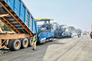  <div class="bildtext">4 The enormous 16.4-ton capacity of the Vögele mobile feeder assures an uninterrupted supply of mix to the road paver. Hamm rollers then take over and compact the asphalt</div> 