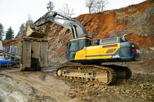  2 	Mit langem Monoblock und 3400-mm-Stiel lädt der 52-t-Bagger Grauwacke in die mobile Brechanlage 