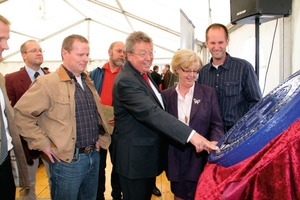  2	Geschenk an die Haver &amp; Boecker-Gesellschafter Dr. Reinhold Festge (Mitte) und Ehefrau Susanne: ein Kanaldeckel aus Münster mit aufgedrucktem Firmenjubiläum 