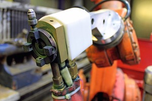  2 Spray head mounted on a robot arm for atmospheric plasma spraying. The powder is fed from above to the centrally emitted plasma jet 