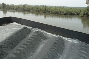  10	Lineare Materialhalden im Lastkahn, aufgehaldet mit radialem, teleskopischen Schiffsbelader, die es in der logistischen Kette dem Greiferkran erleichtern, das Material während des Umschlags aufzunehmen • Linear stockpiles of material on the barge made by the radial telescopic shiploader makes it more efficient in the ­logistics chain for the grab crane to pick up the material during the transhipping process 