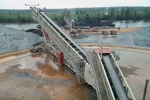  1	Blick auf die Einspeicherungsanlage von der Fahrerkabine, mit 20&nbsp;m langem Gliederbandförderer und Radial-Teleskop-Absetzer TS&nbsp;850 View&nbsp;of&nbsp;stacking system from operators cabin, ­showing 20&nbsp;m link conveyor and TS&nbsp;850 radial telescopic stacker 